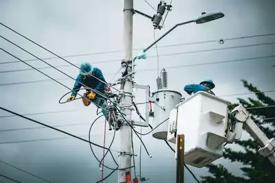 Electrician wearing safety gear working on lines