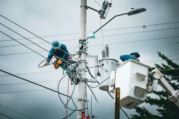 Electrician wearing safety gear working on lines