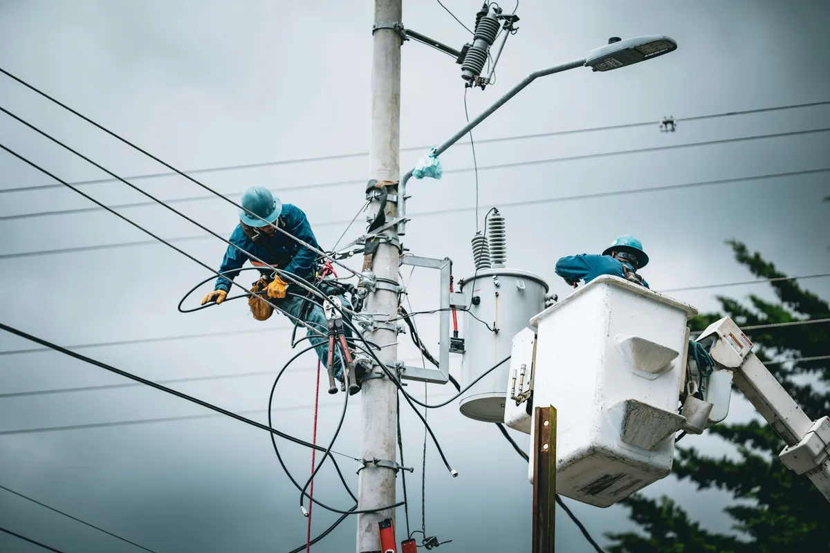Electrician wearing safety gear working on lines